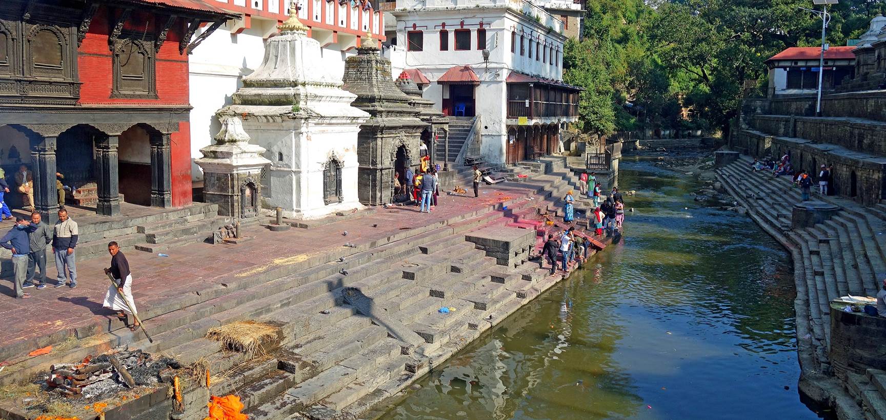 A group of people walking on the side of a river

Description automatically generated