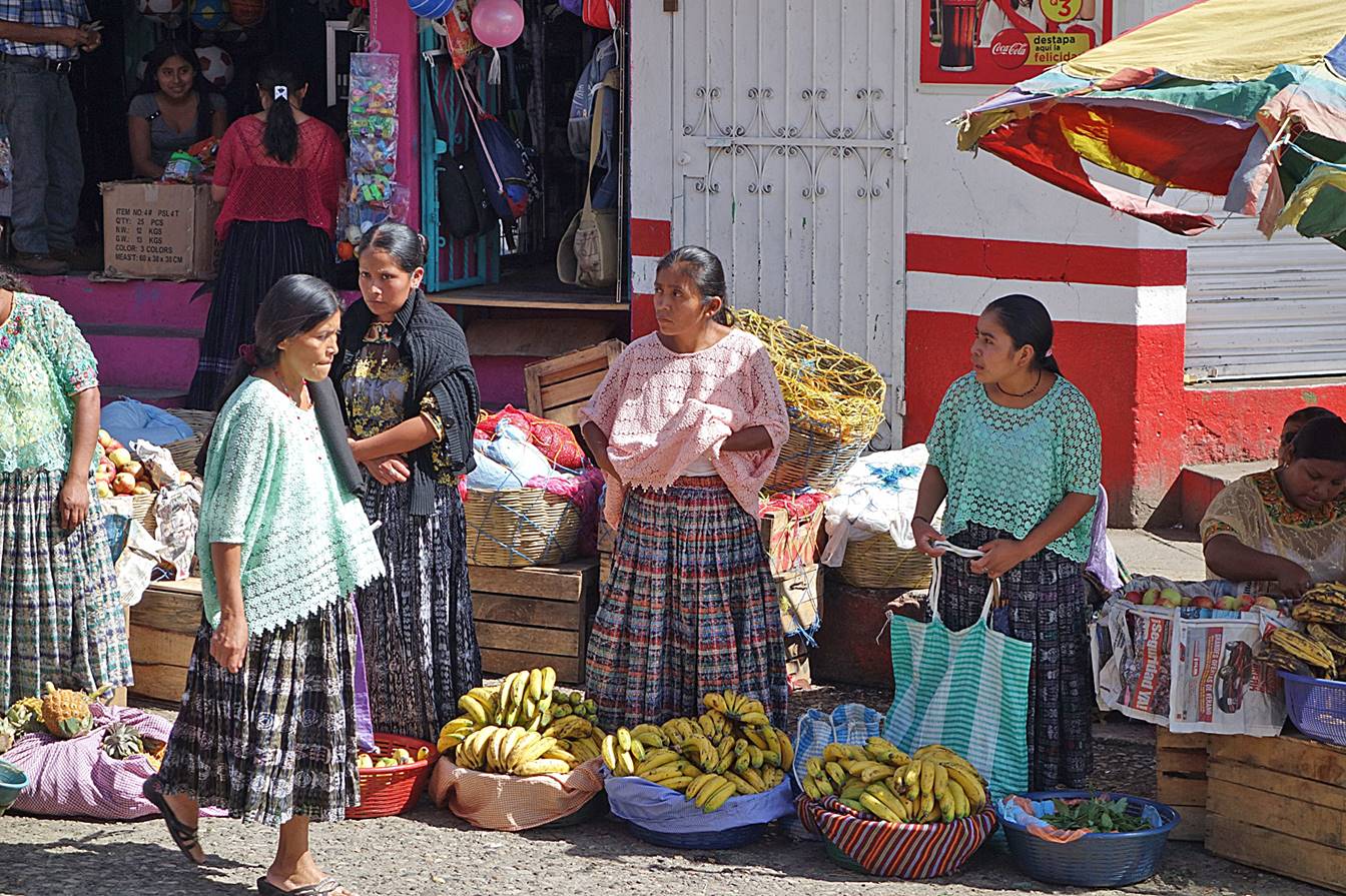 A group of women standing outside a market

Description automatically generated