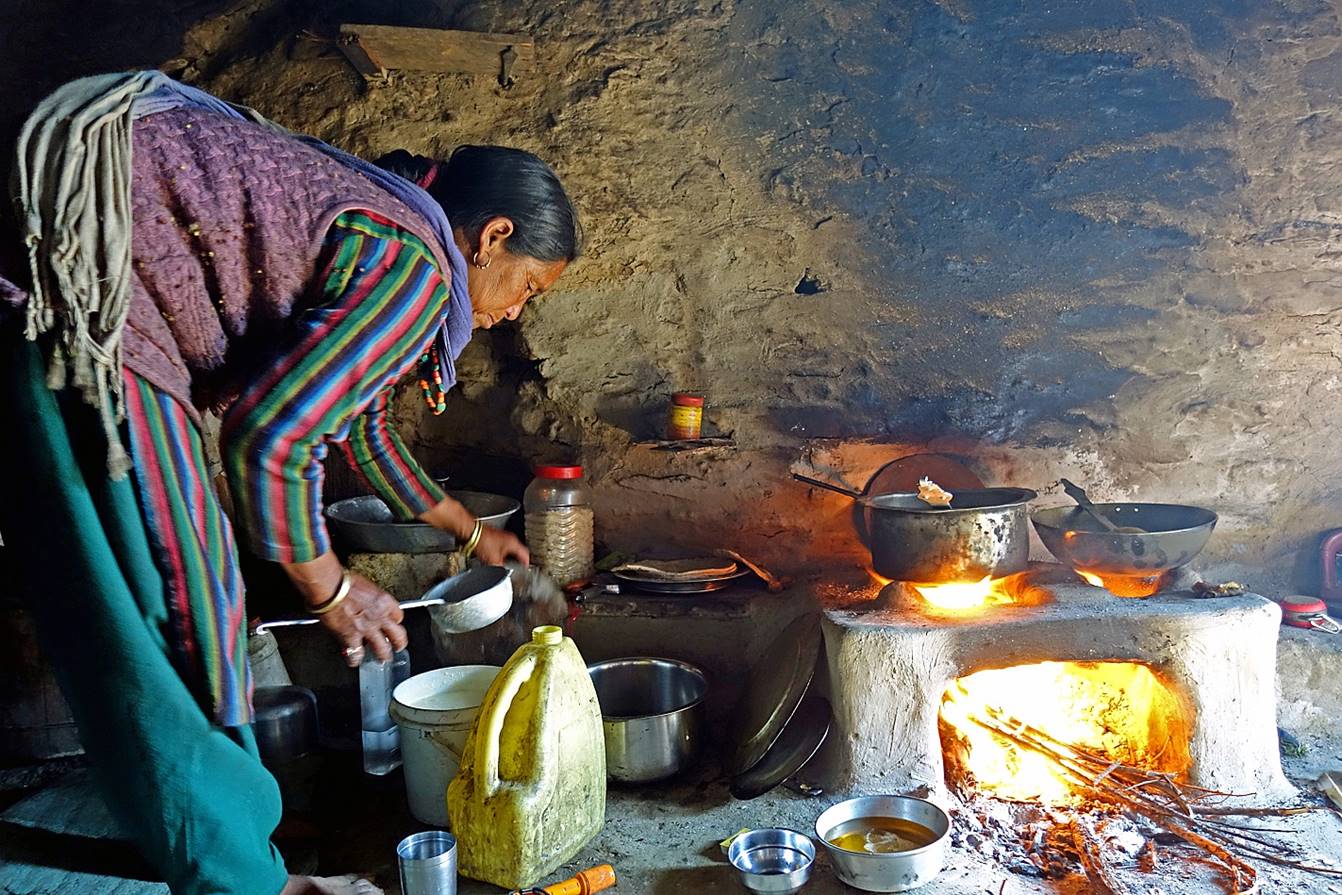 A person cooking in a stone oven

Description automatically generated