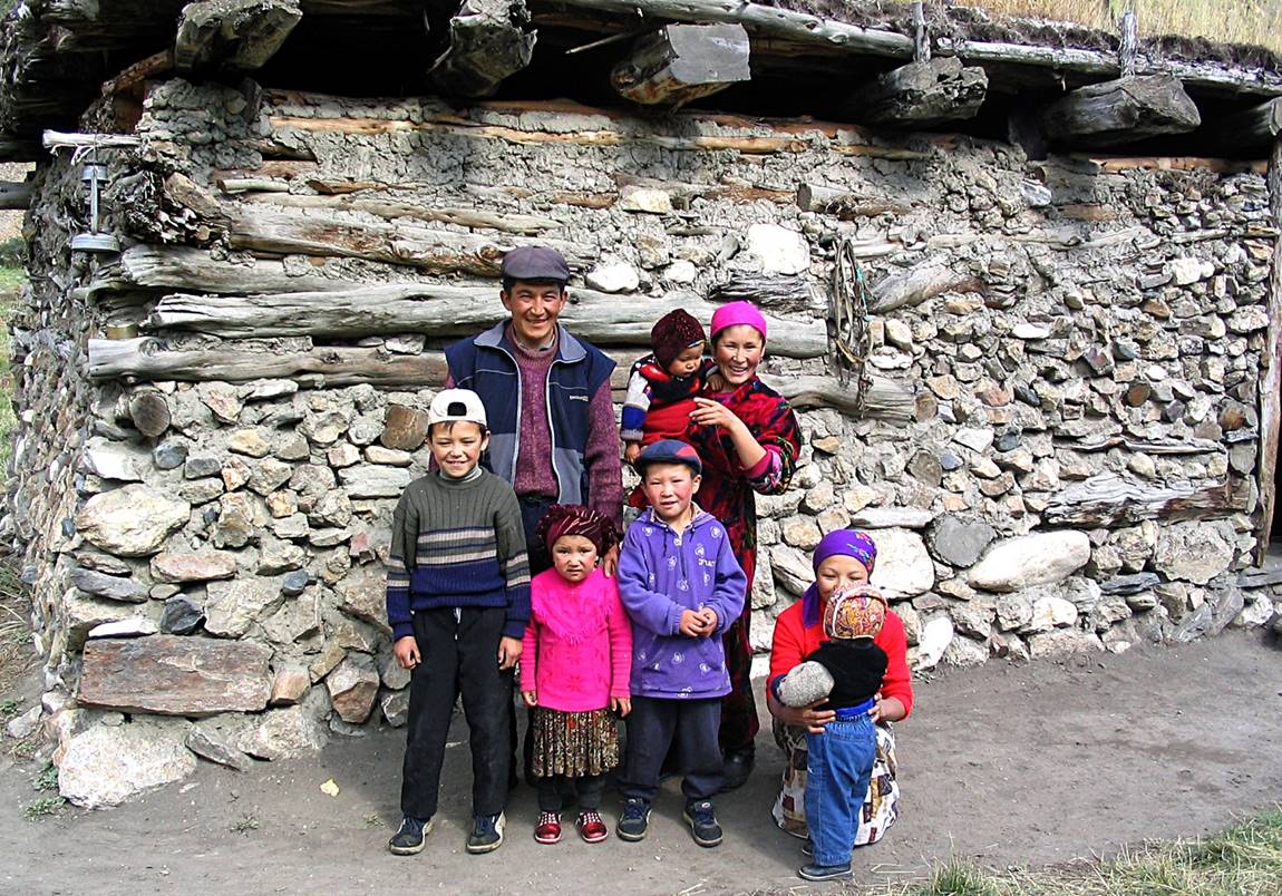 A group of people standing in front of a stone wall

Description automatically generated