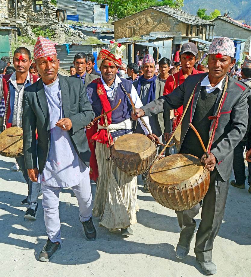 A group of men walking with drums

Description automatically generated