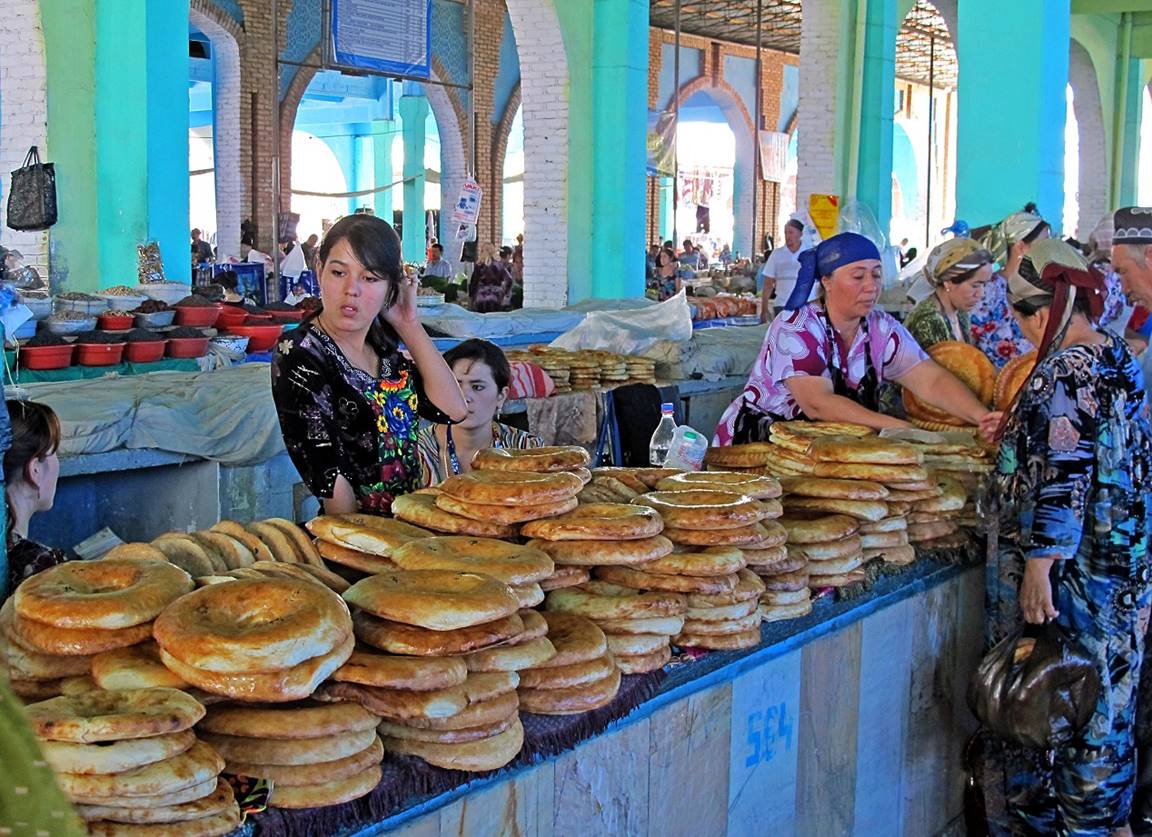 A group of women standing at a counter with bread

Description automatically generated