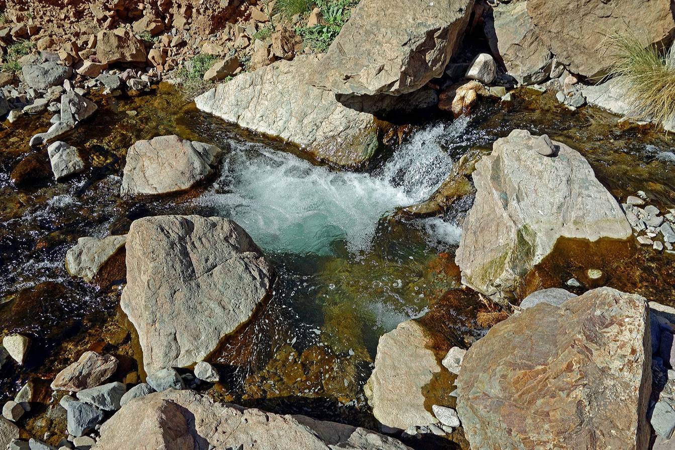 A stream of water surrounded by rocks

Description automatically generated