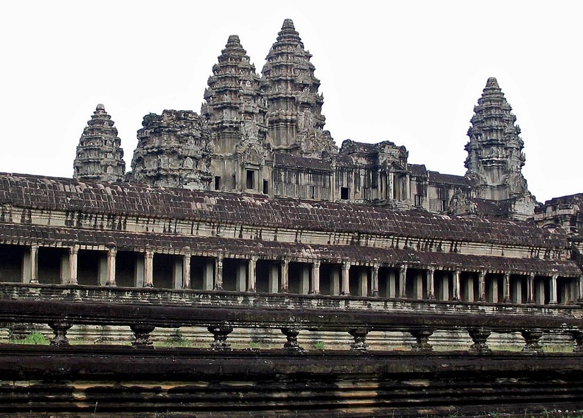 A large stone building with many towers with Angkor Wat in the background

Description automatically generated