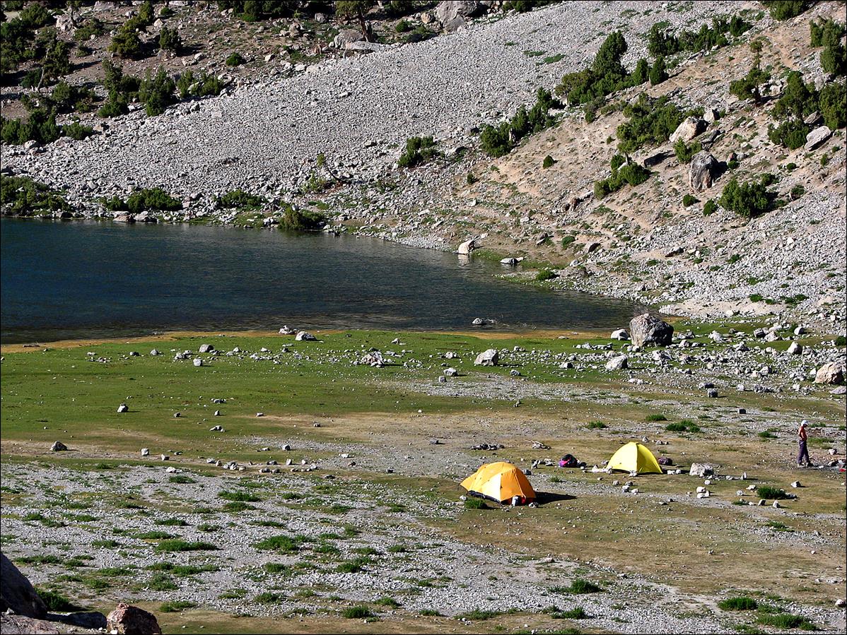 A group of tents on a rocky shore

Description automatically generated