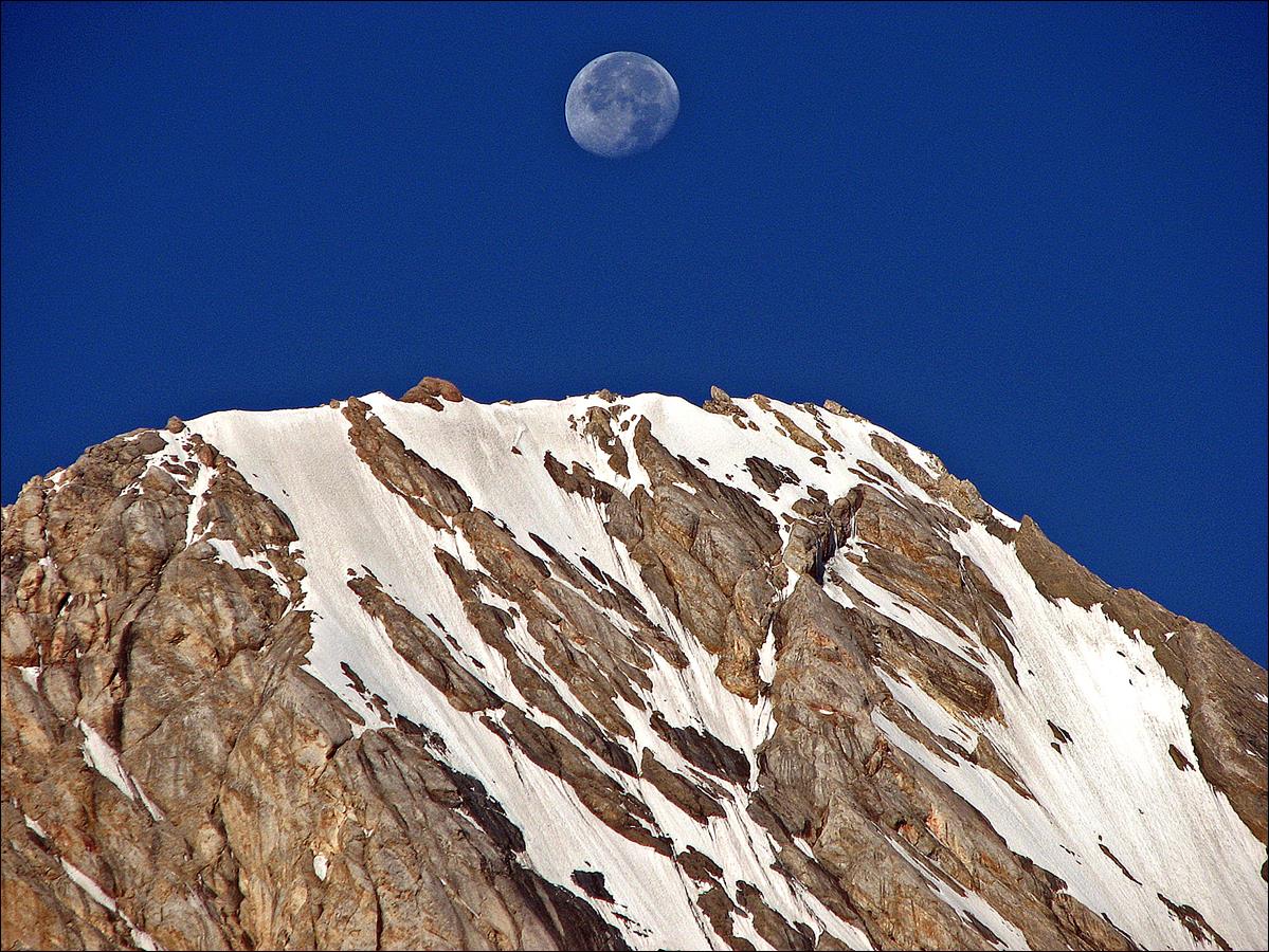 A mountain with snow and the moon

Description automatically generated
