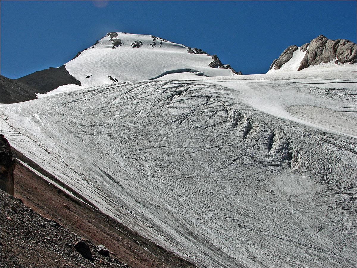 A snow covered mountain with blue sky

Description automatically generated