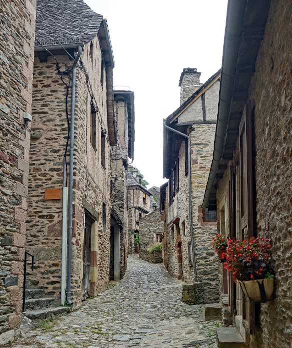 A stone alleyway with stone buildings

Description automatically generated