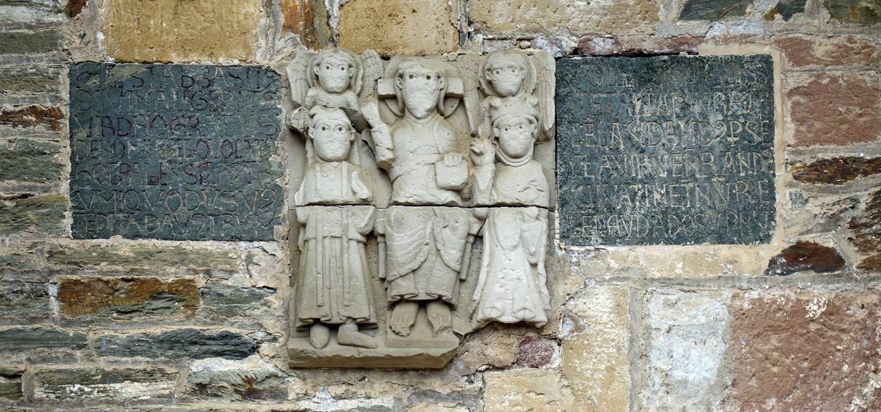 A stone carving of a group of people

Description automatically generated