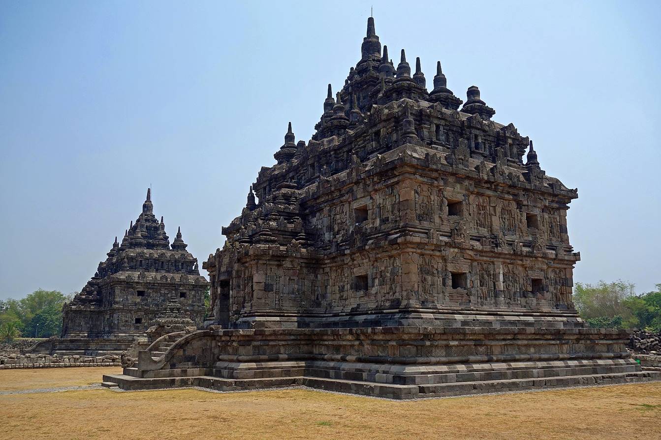 A stone building with many towers with Prambanan in the background

Description automatically generated with medium confidence