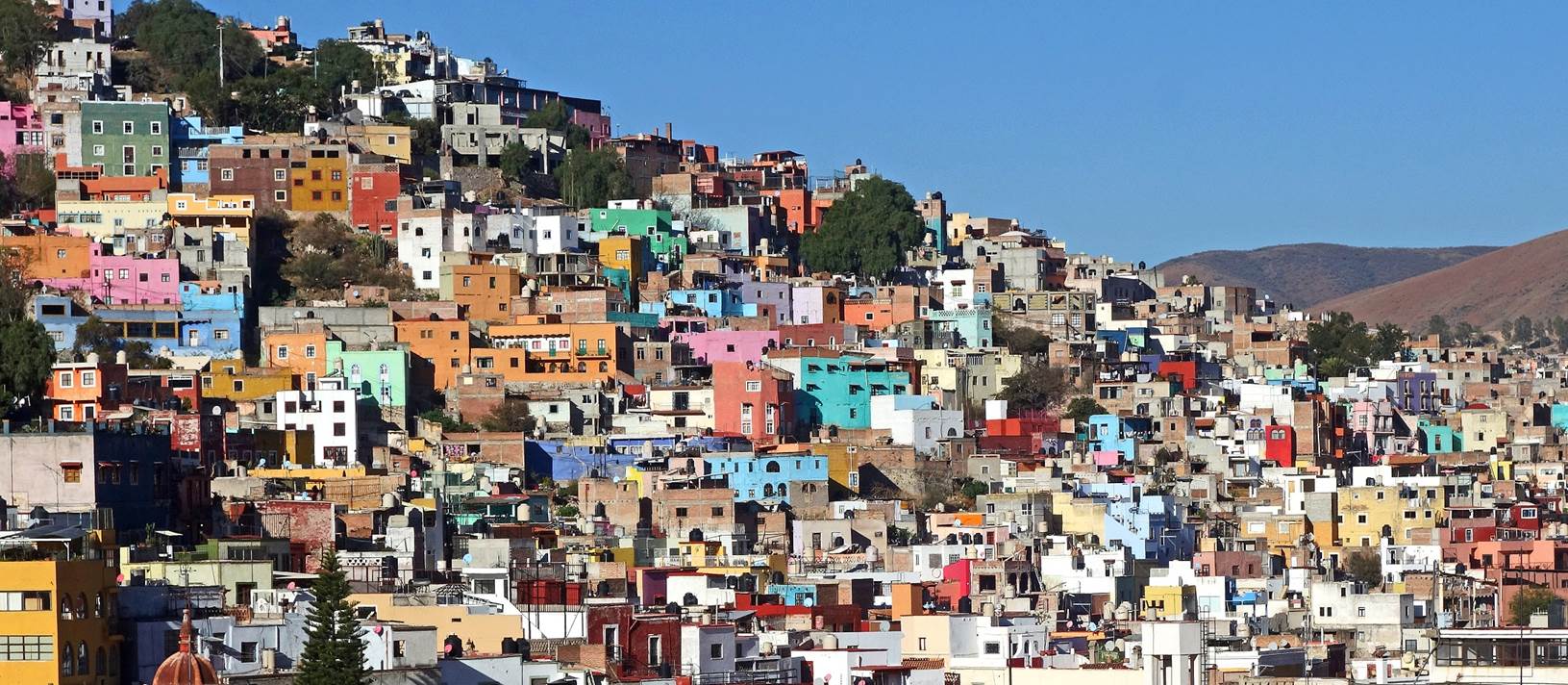 A group of colorful buildings on a hill

Description automatically generated
